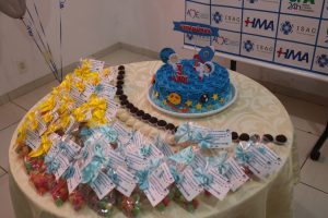 Mesa com um bolo temático comemorando os três anos de implantação da UTI PEdiátrica do HMA
